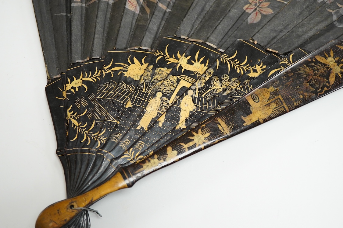 Four 19th century Chinese gilt-decorated black lacquer fans with figure painted leaves, two cased, largest 41cm